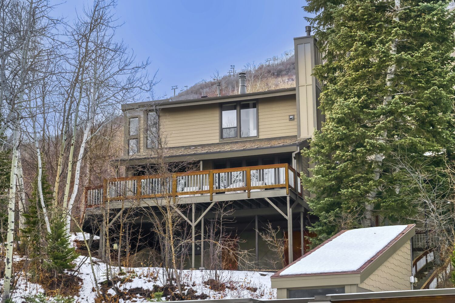 Mountain retreat with spacious deck surrounded by aspen trees and natural forest setting.