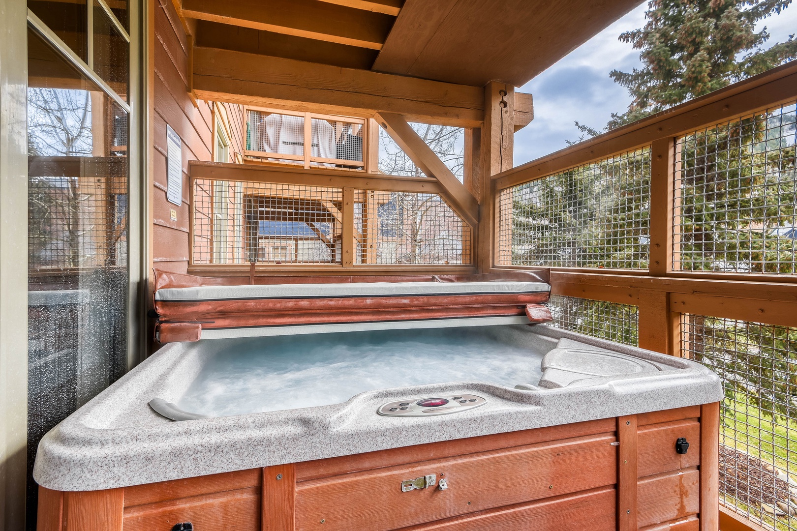 Soak under the open sky in your private hot tub, surrounded by peaceful forest views and cozy wooden shelter overhead.