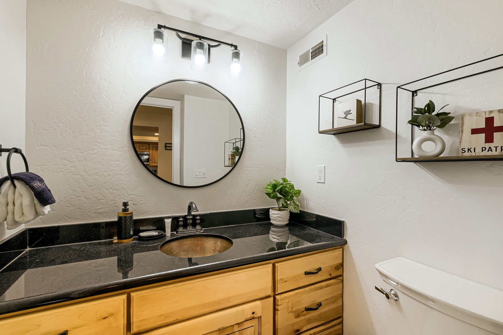 Your private bathroom features modern fixtures, thoughtful lighting, and warm wood tones. Fresh greenery and open shelving create a welcoming, spa-like atmosphere perfect for unwinding after your alpine adventures.
