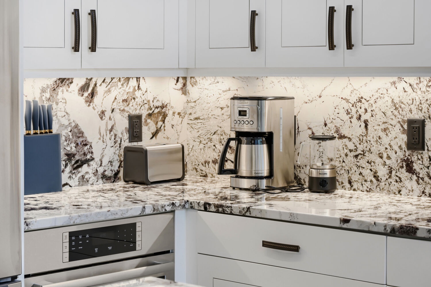 Prepare your morning coffee in this sleek modern kitchen, featuring granite countertops, stainless steel appliances, and plenty of storage. Everything you need is right at your fingertips.