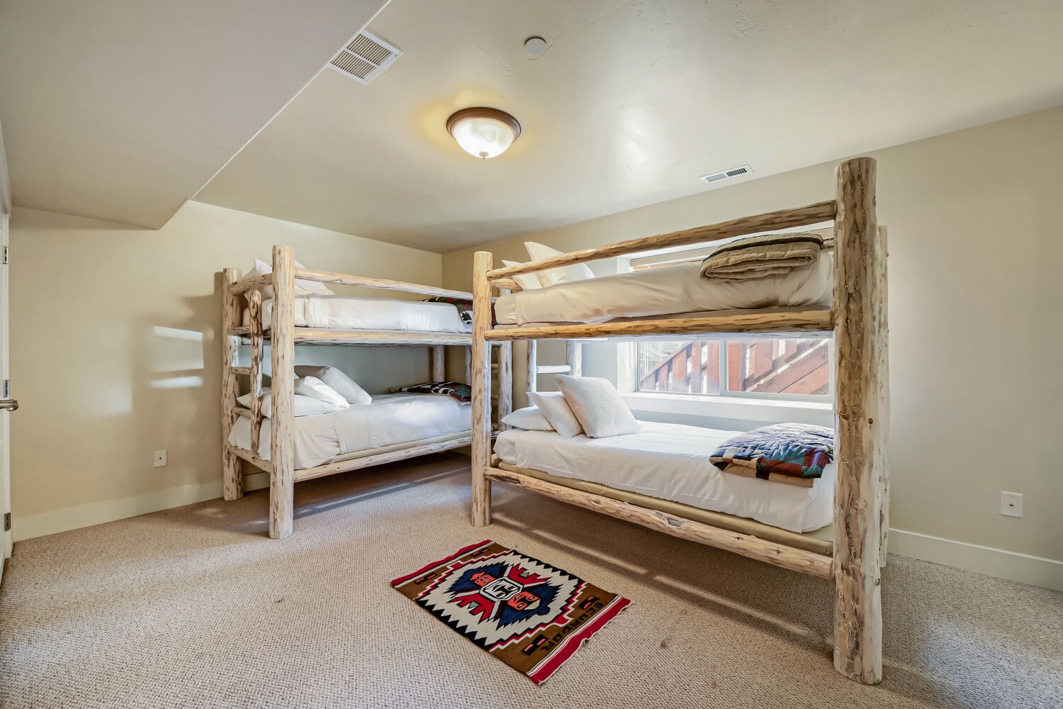 These rustic log bunk beds bring mountain charm to your sleeping quarters—cozy up with the whole crew in this spacious retreat.
