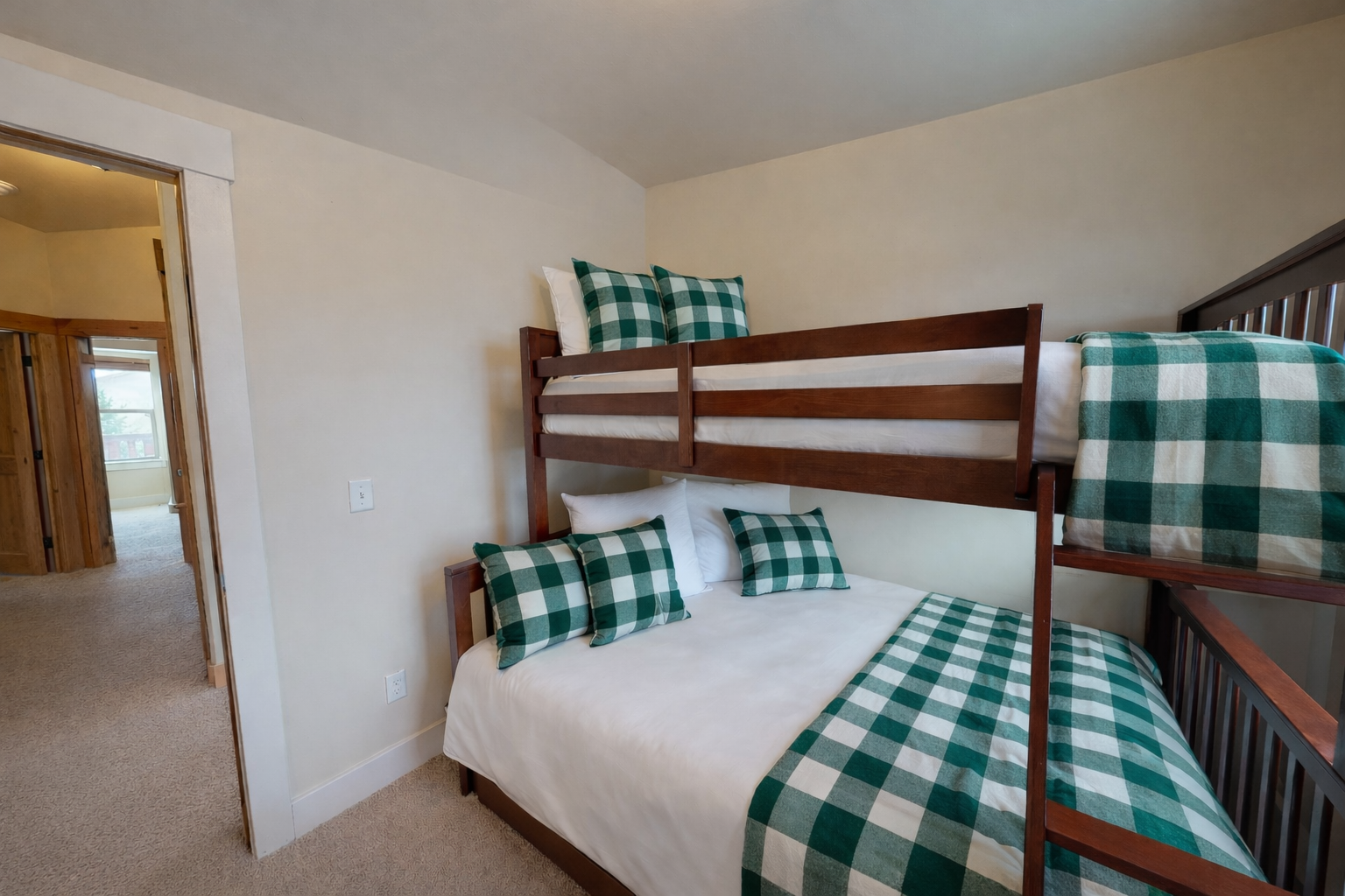 Your cozy bunk room features charming green gingham bedding and warm wood frames, perfect for family adventures together.