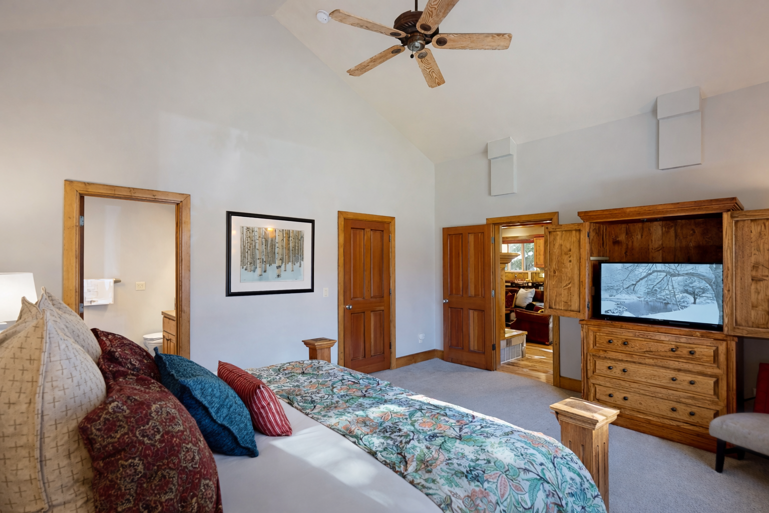 Unwind in the primary suite, featuring a cozy king-sized bed with a rustic wood frame, quality linens, and serene decor for a peaceful mountain retreat.