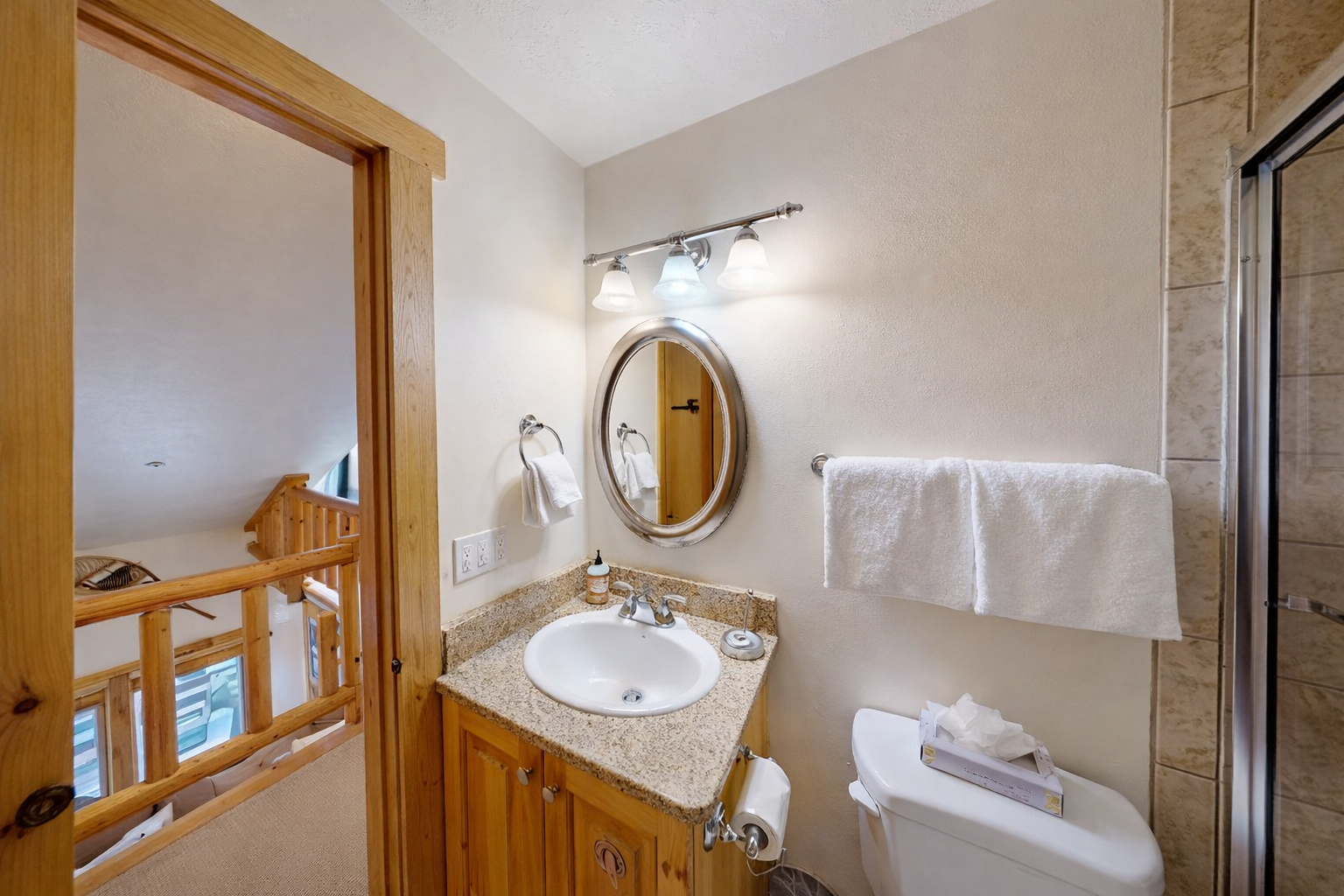 Refresh in your well-appointed bathroom featuring granite countertops, plush towels, and thoughtful lighting for your comfort.