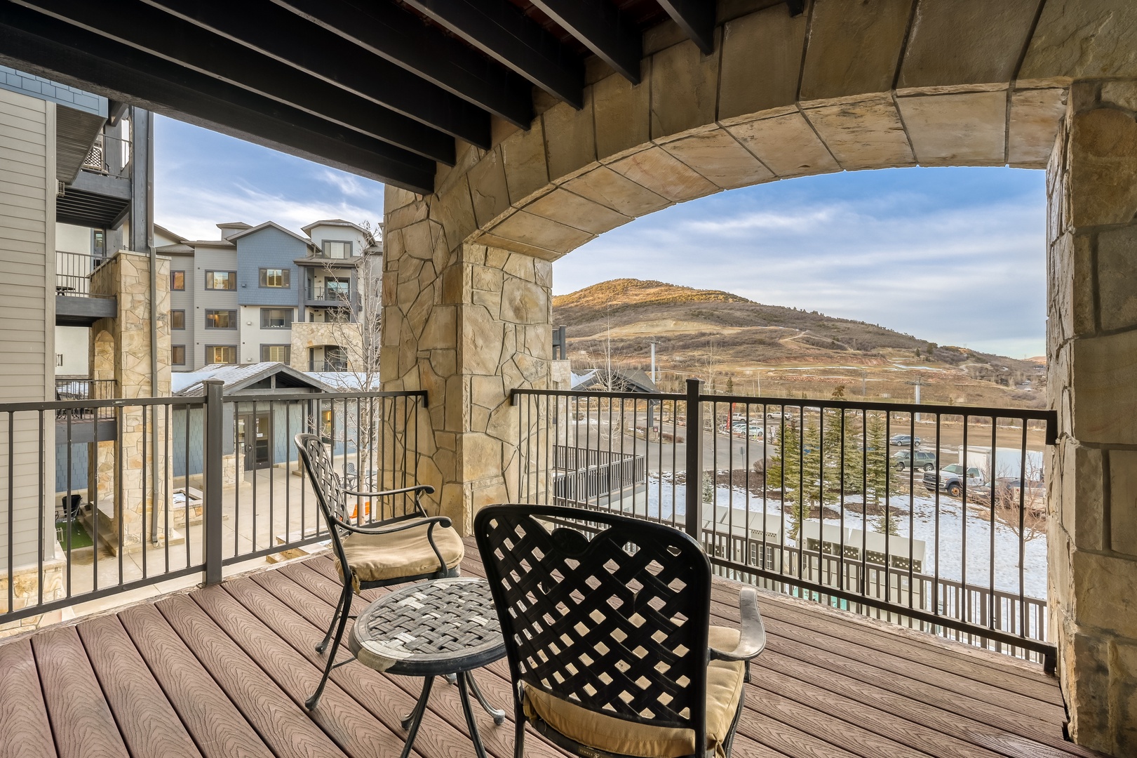 Your private balcony offers stunning mountain vistas through elegant stone archways, where morning coffee tastes better with panoramic views.