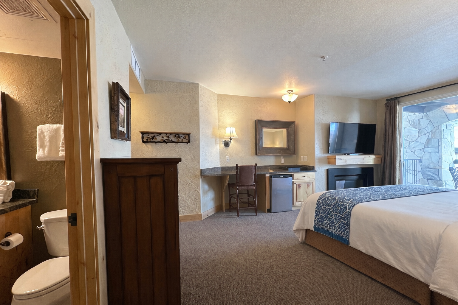 Relax in this spacious master suite featuring a king bed and handcrafted wood furniture. A serene retreat designed for ultimate comfort and a restful night's sleep.