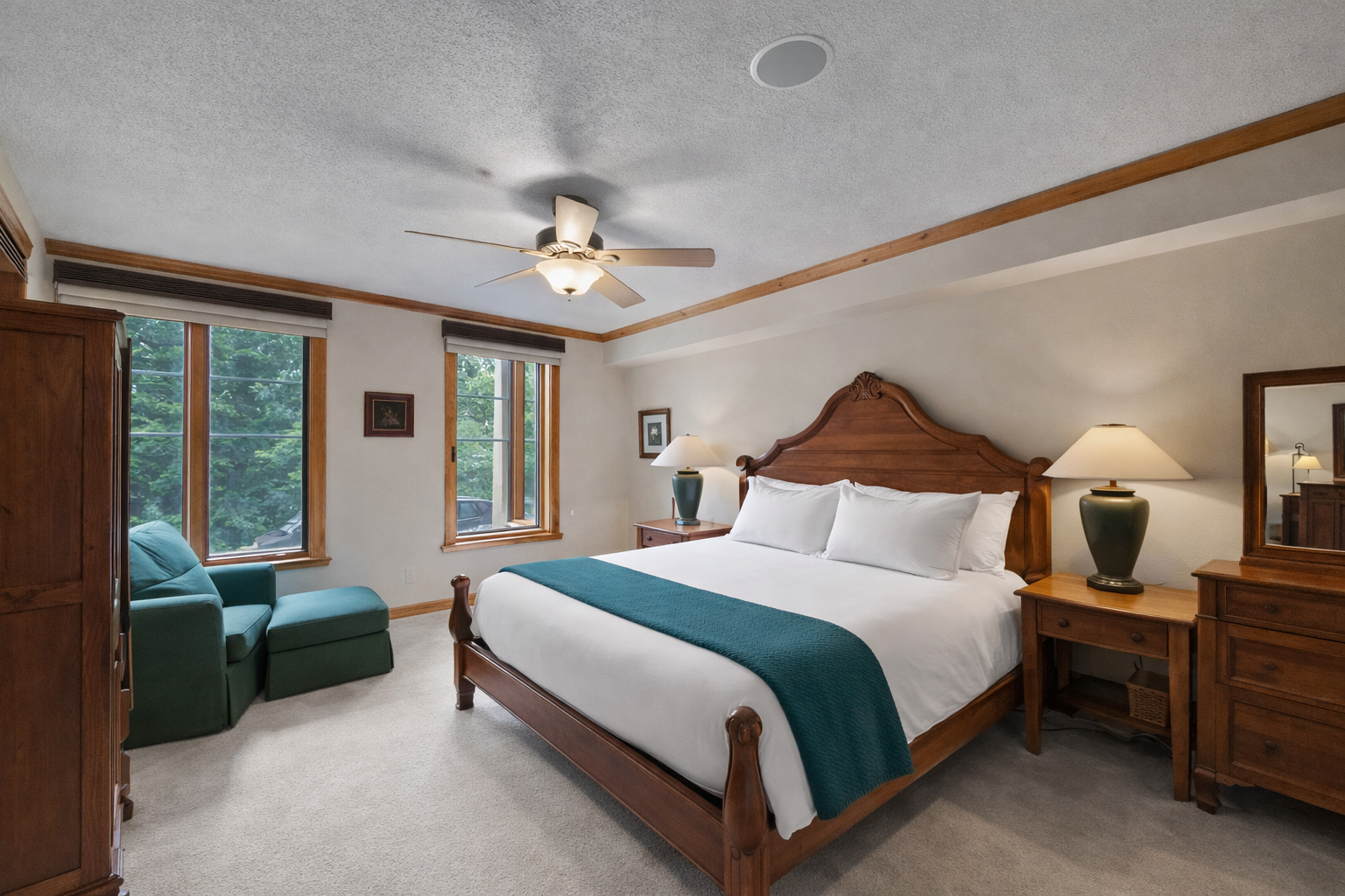 Inviting primary bedroom featuring a comfortable king-size bed, cozy seating area, ceiling fan, and ample natural light. A tranquil retreat for a restful stay in the mountains.