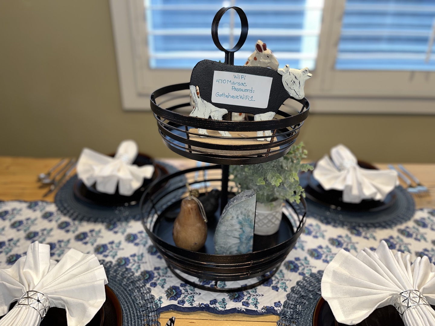 Gather around this rustic wooden dining table, featuring a mix of high-back chairs and bench seating. The space is beautifully accented with mountain-inspired decor, a patterned area rug, and soft overhead lighting.