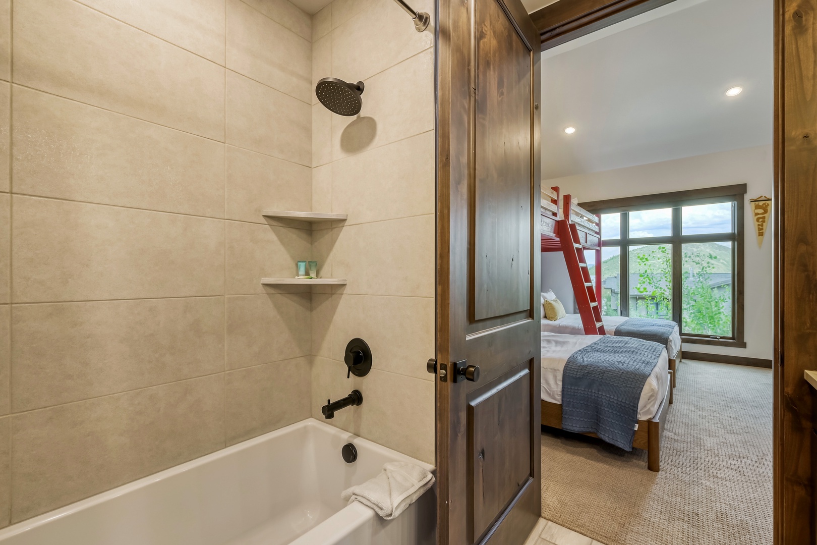 This charming space features a tiled tub and shower combo just steps from your cozy bedroom with serene hillside views, perfect for unwinding after a day of adventure.