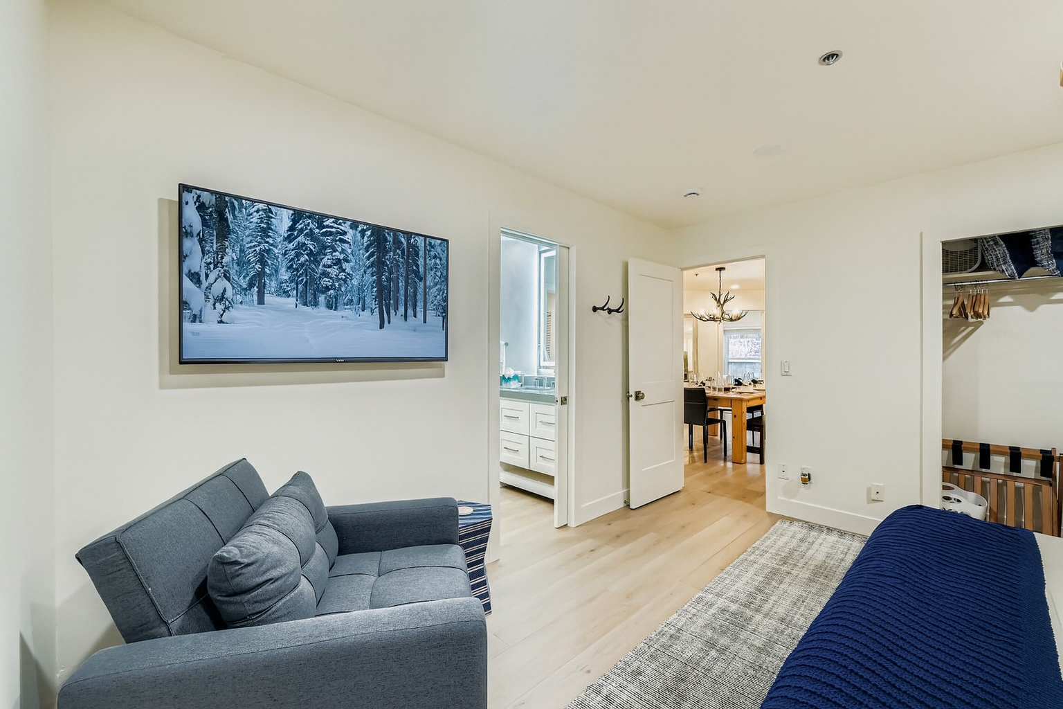 Relax in your bright, modern living space with a large flat-screen TV and comfortable seating, perfect for unwinding after exploring the area.