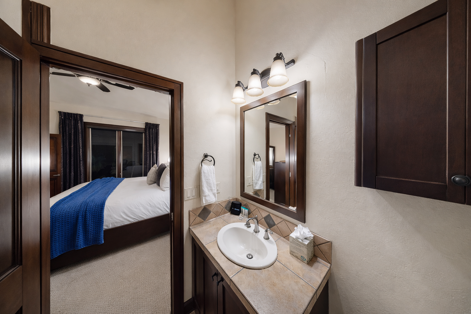 Your private bathroom features elegant tile countertops and warm lighting, with your cozy bedroom just steps away.