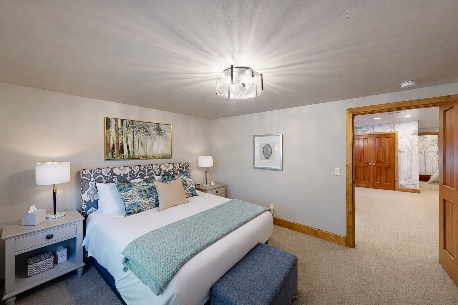 Drift off to peaceful sleep in your cozy queen bedroom, surrounded by warm wood trim and gentle natural light filtering through treetop views.