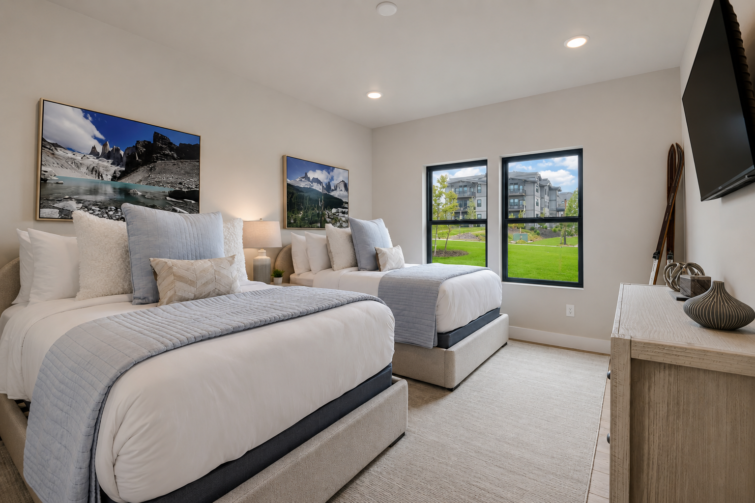 Drift off in serene comfort with two plush beds dressed in soft linens, mountain artwork above you, and windows framing green lawns—your peaceful mountain retreat awaits.