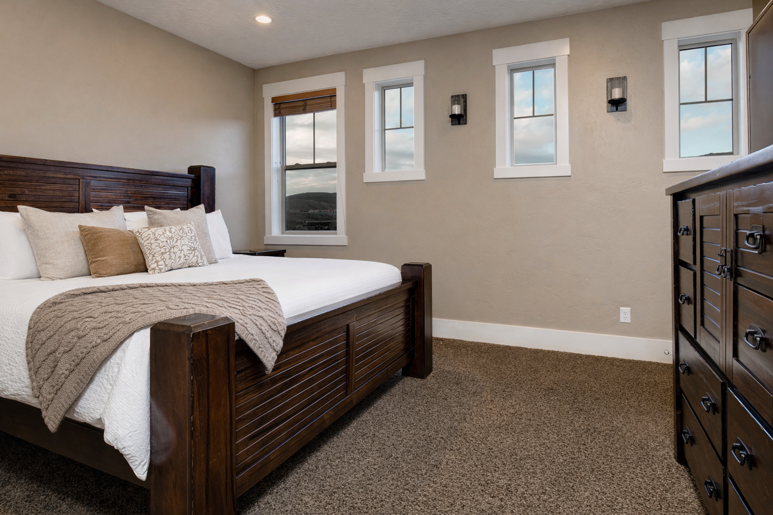 Sink into crisp linens and wake to mountain views through multiple windows. Your bedroom features rich wood furniture and peaceful neutral tones for ultimate relaxation.