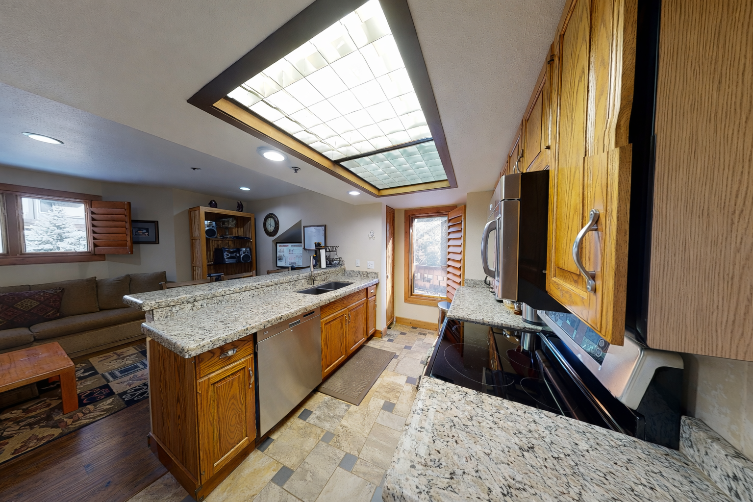 Your gourmet kitchen features granite countertops, warm wood cabinetry, and a stunning skylight that bathes the space in natural light.