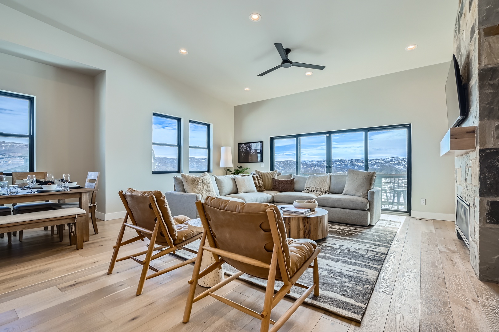 Relax in your stylish living space with panoramic mountain views through floor-to-ceiling windows, cozy seating, and elegant finishes that blend modern comfort with natural surroundings.