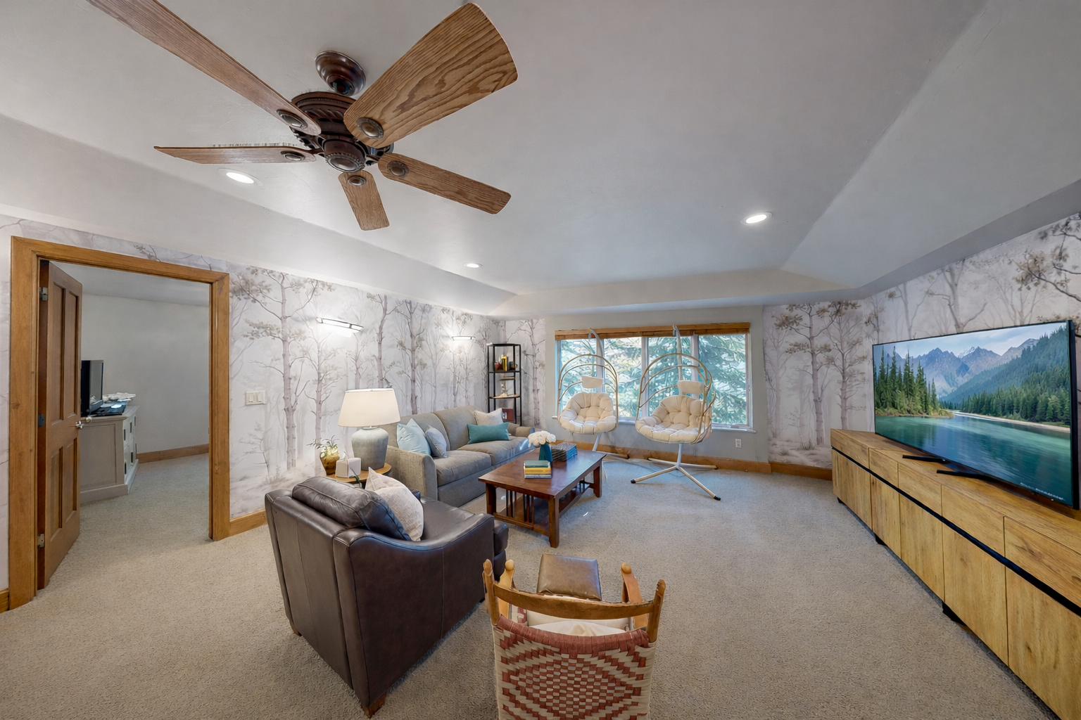 Unwind in your spacious living room with cozy seating, nature-inspired wallpaper, and a large TV for movie nights after exploring the mountains.