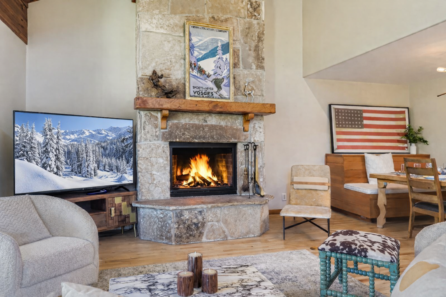 Escape to a cozy, rustic retreat! Enjoy this charming mountain living room featuring a stone fireplace, natural wood beams, and comfortable seating.