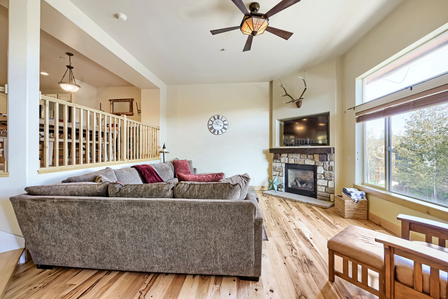 Stretch out on plush seating beneath vaulted ceilings, where a cozy fireplace and abundant natural light create your perfect mountain retreat.