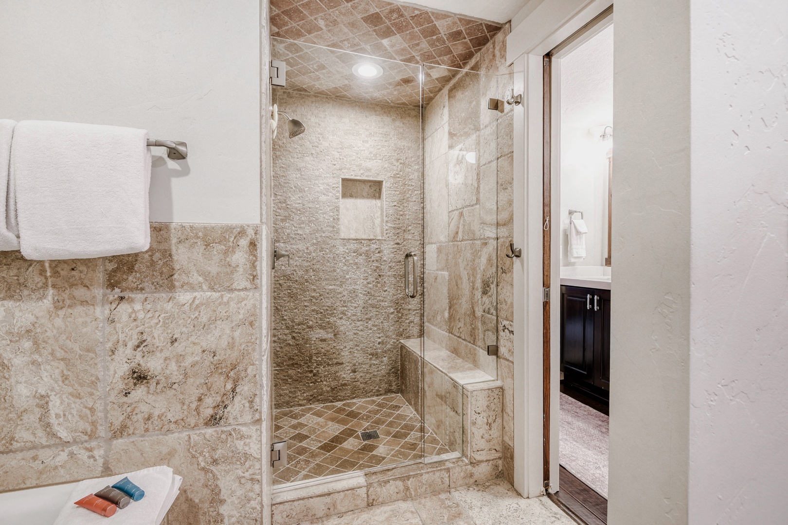 Unwind in your luxurious stone-tiled shower with rain head and built-in seating—a spa-like retreat after your adventures.