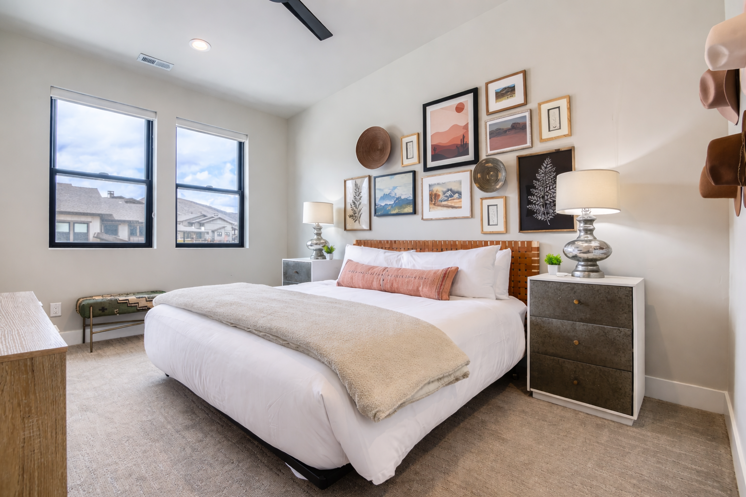 Rest peacefully in your thoughtfully designed bedroom, featuring crisp linens, artistic gallery wall, and natural light streaming through oversized windows.