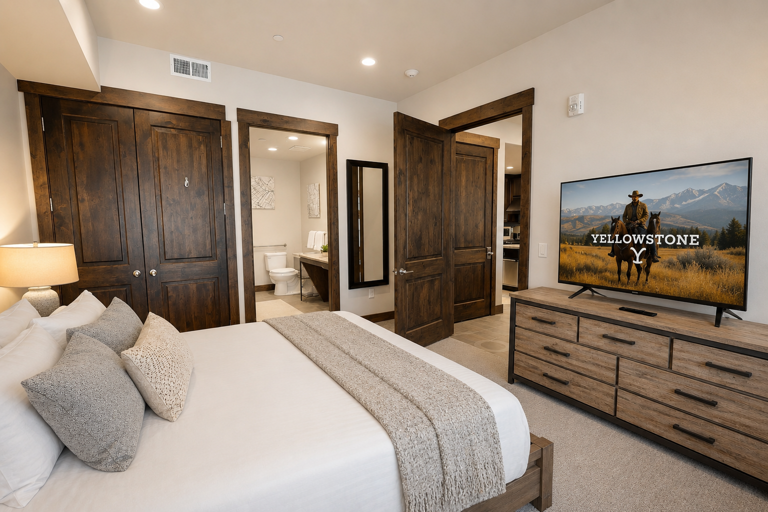 Unwind in this cozy bedroom featuring a plush bed, warm wood accents, modern entertainment, and an ensuite bathroom—your perfect retreat after a day of adventure.