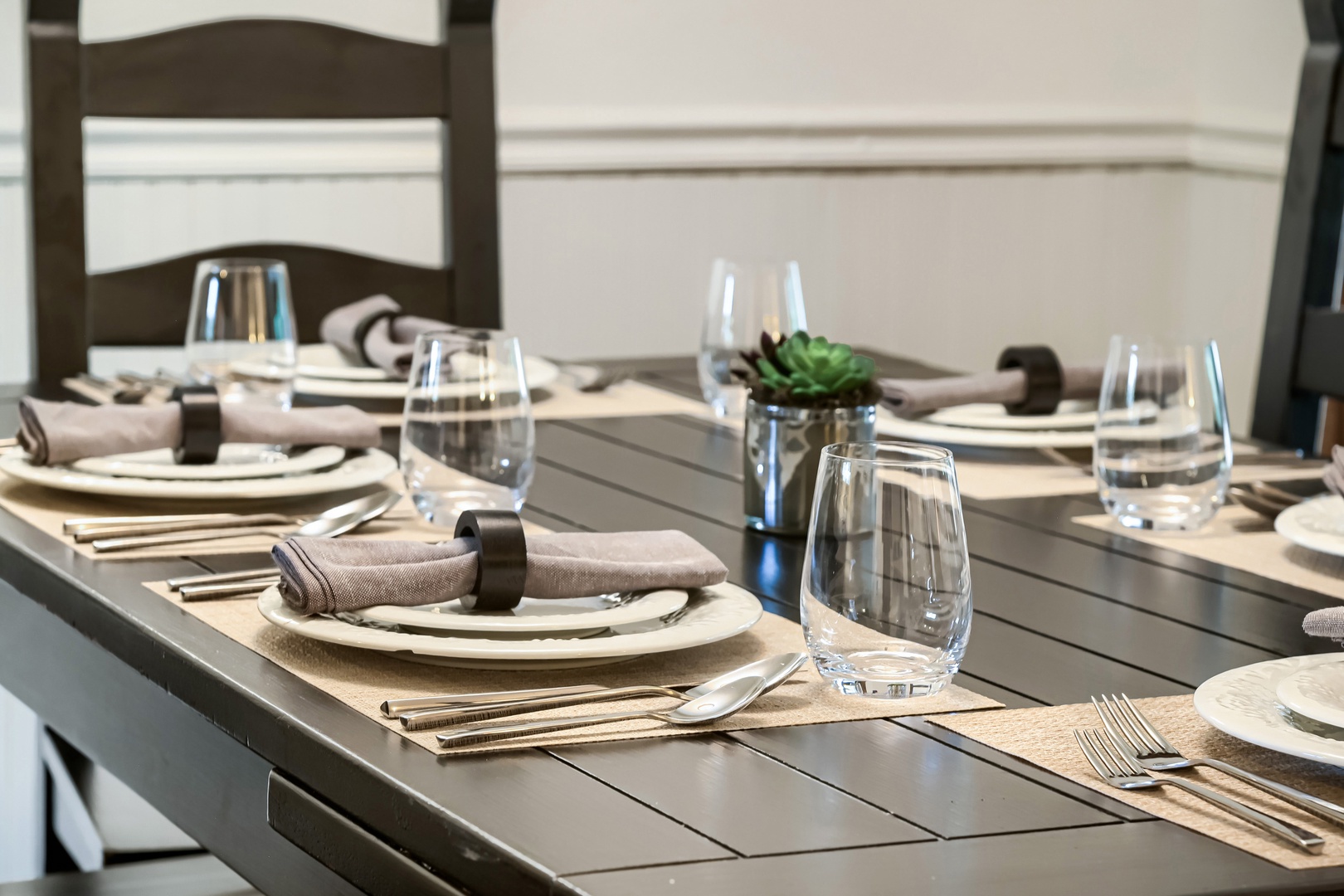 Your outdoor dining table awaits with elegant place settings and modern touches—perfect for savoring meals in the fresh air while enjoying serene water views beyond.