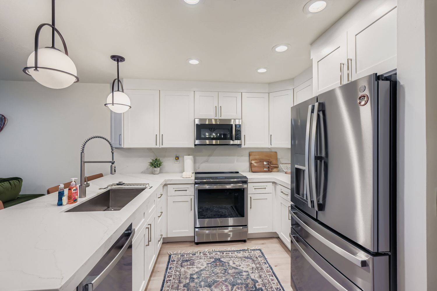 Your modern kitchen features pristine white cabinets, stainless steel appliances, and granite countertops - everything you need to prepare your favorite meals in style.