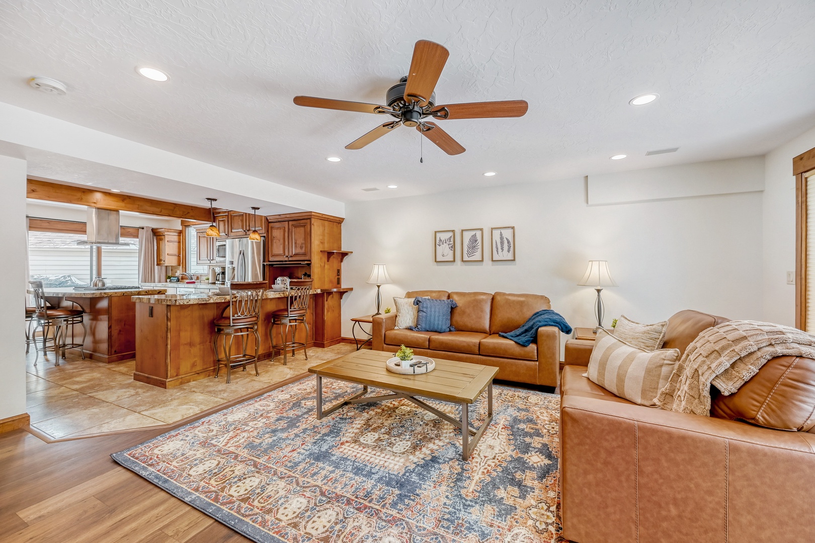 Relax in your open-concept living space featuring rich leather seating, warm wood finishes, and a fully-equipped kitchen perfect for gathering.