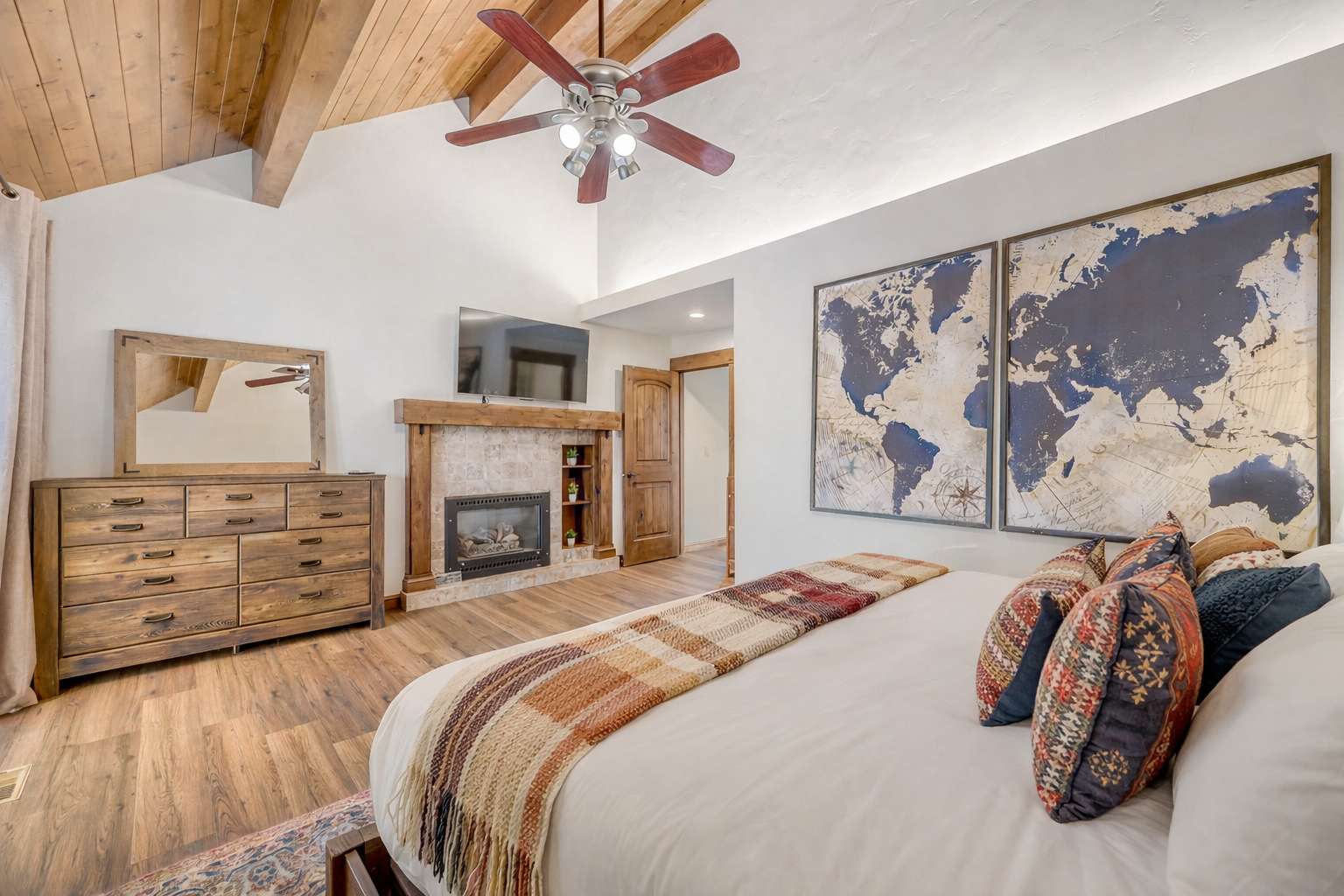 Unwind in your spacious master bedroom with soaring vaulted ceilings, cozy fireplace, and inspiring world map artwork.