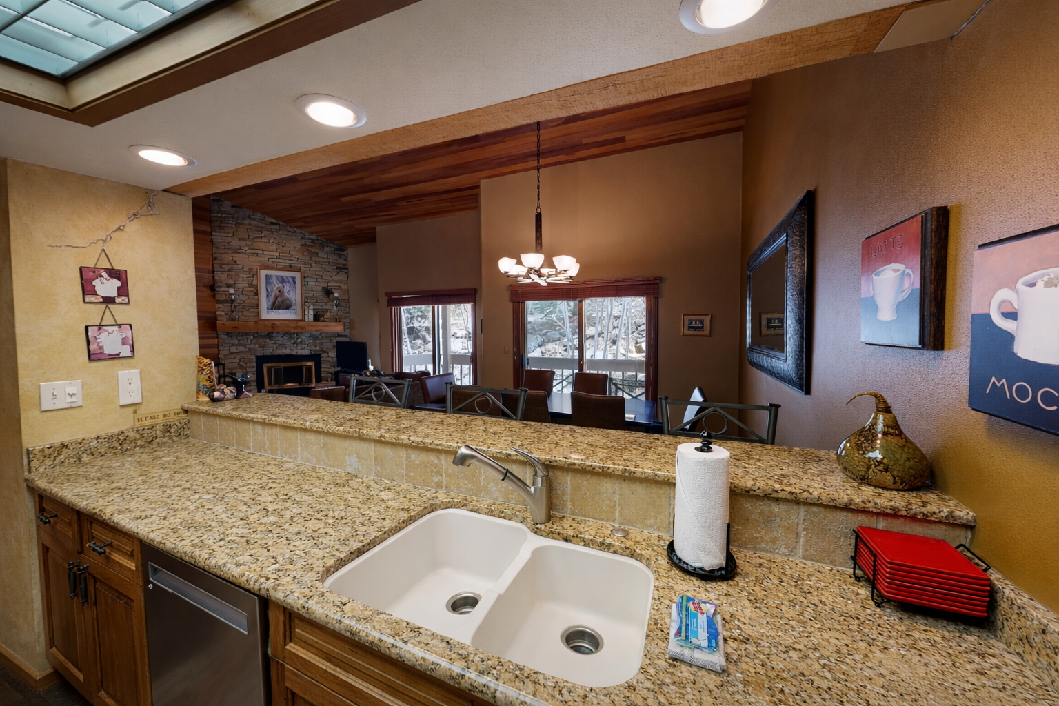 Your spacious kitchen features granite countertops and flows into the cozy living area with stone fireplace—perfect for cooking together.