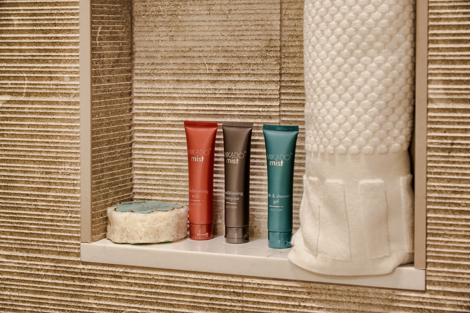Your bathroom comes thoughtfully stocked with premium toiletries displayed on a sleek built-in shelf, ready to refresh you after a day of exploring.