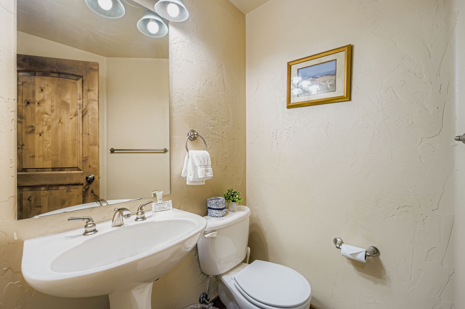 Your private bathroom features a classic pedestal sink and toilet, with thoughtful touches like fresh towels and modern lighting to make you feel right at home.