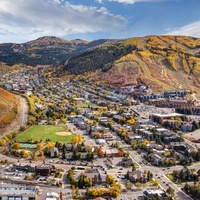 Scenic mountain valley town with colorful autumn foliage covering the surrounding peaks and hillsides.