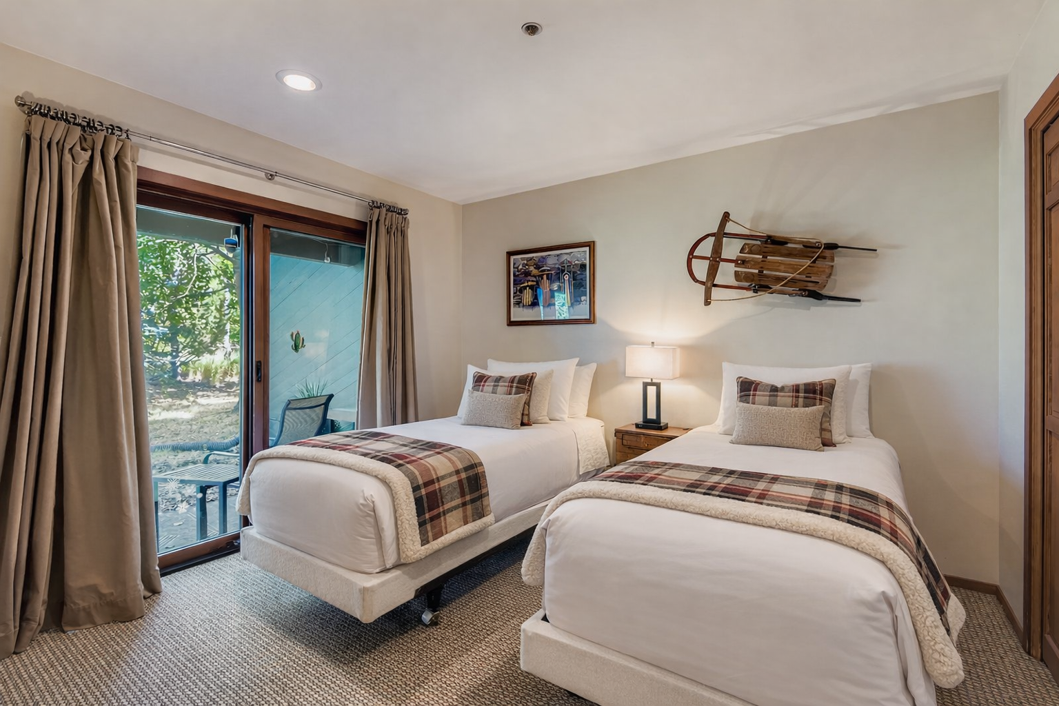 Rest comfortably in this twin bedroom featuring crisp linens and charming plaid accents that create a cozy mountain lodge atmosphere.