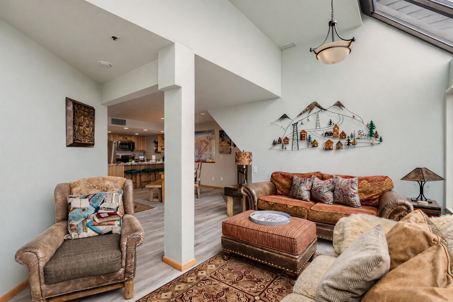 Bright, open-concept living area with large windows, scenic views, skylights, and cozy seating.