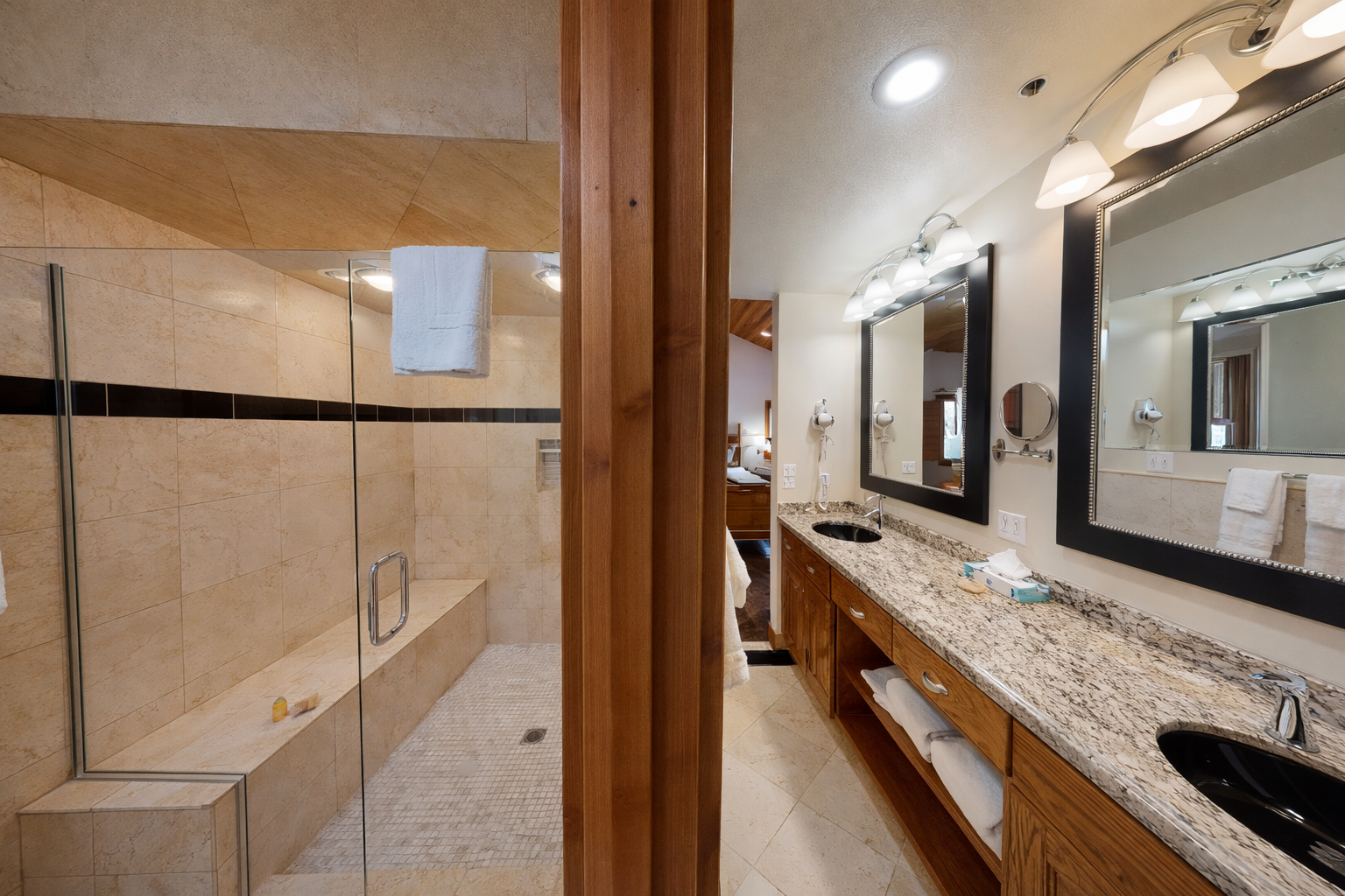 Relax in this modern bathroom featuring a walk-in glass shower, a sleek vanity, and clean tile finishes. It's the perfect spot to refresh after a day outdoors.