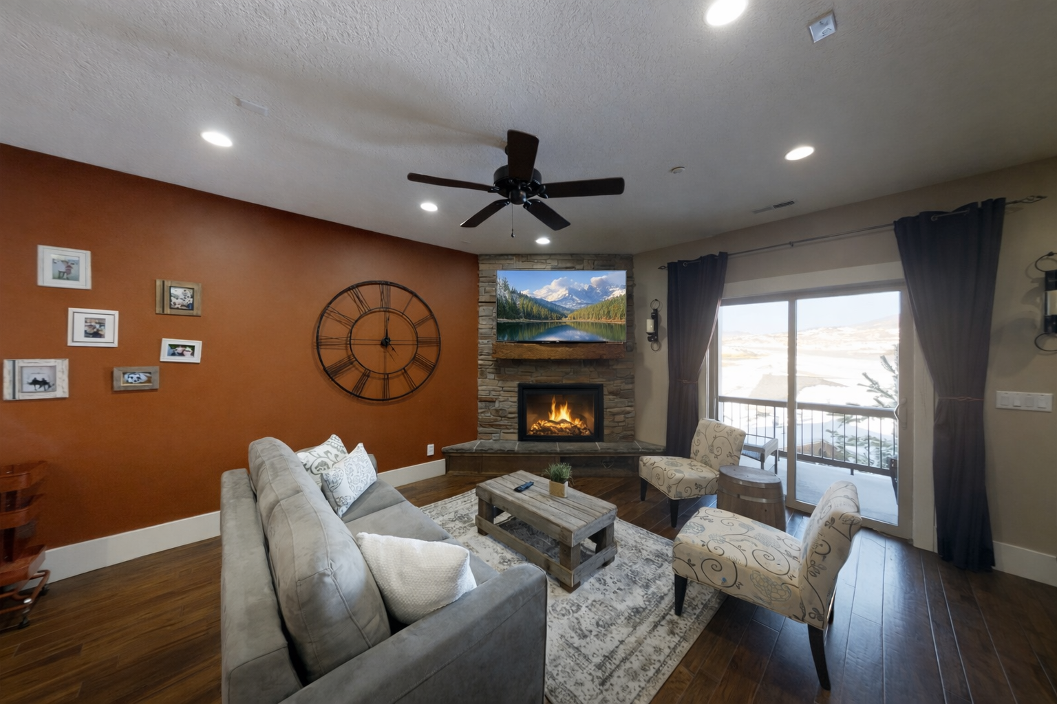 Relax in your cozy living room with a crackling fireplace, comfortable seating, and mountain views from your private balcony.