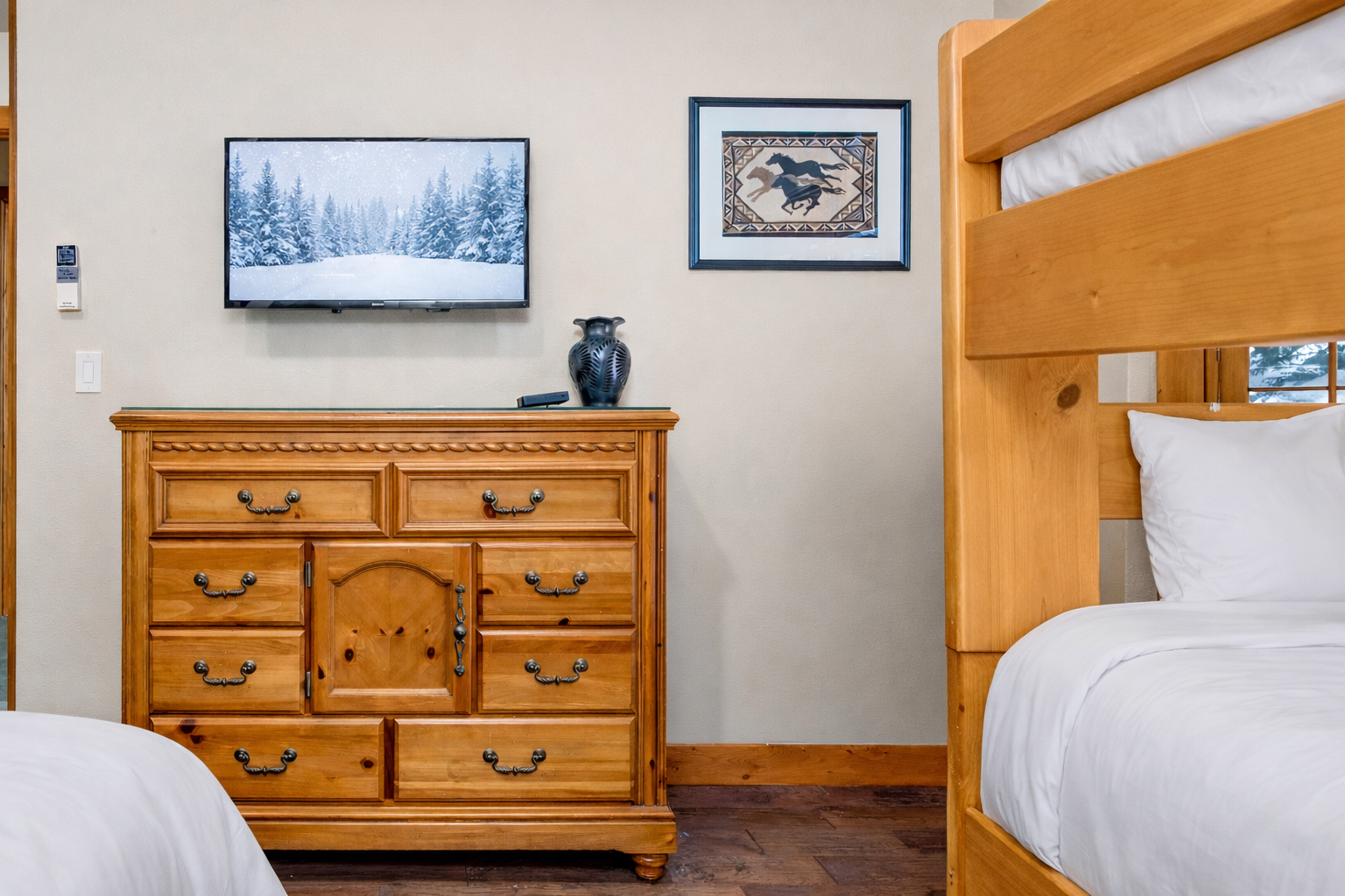 Your cozy bunk room features rustic wood furnishings and mountain-themed art, perfect for family adventures or friend getaways.