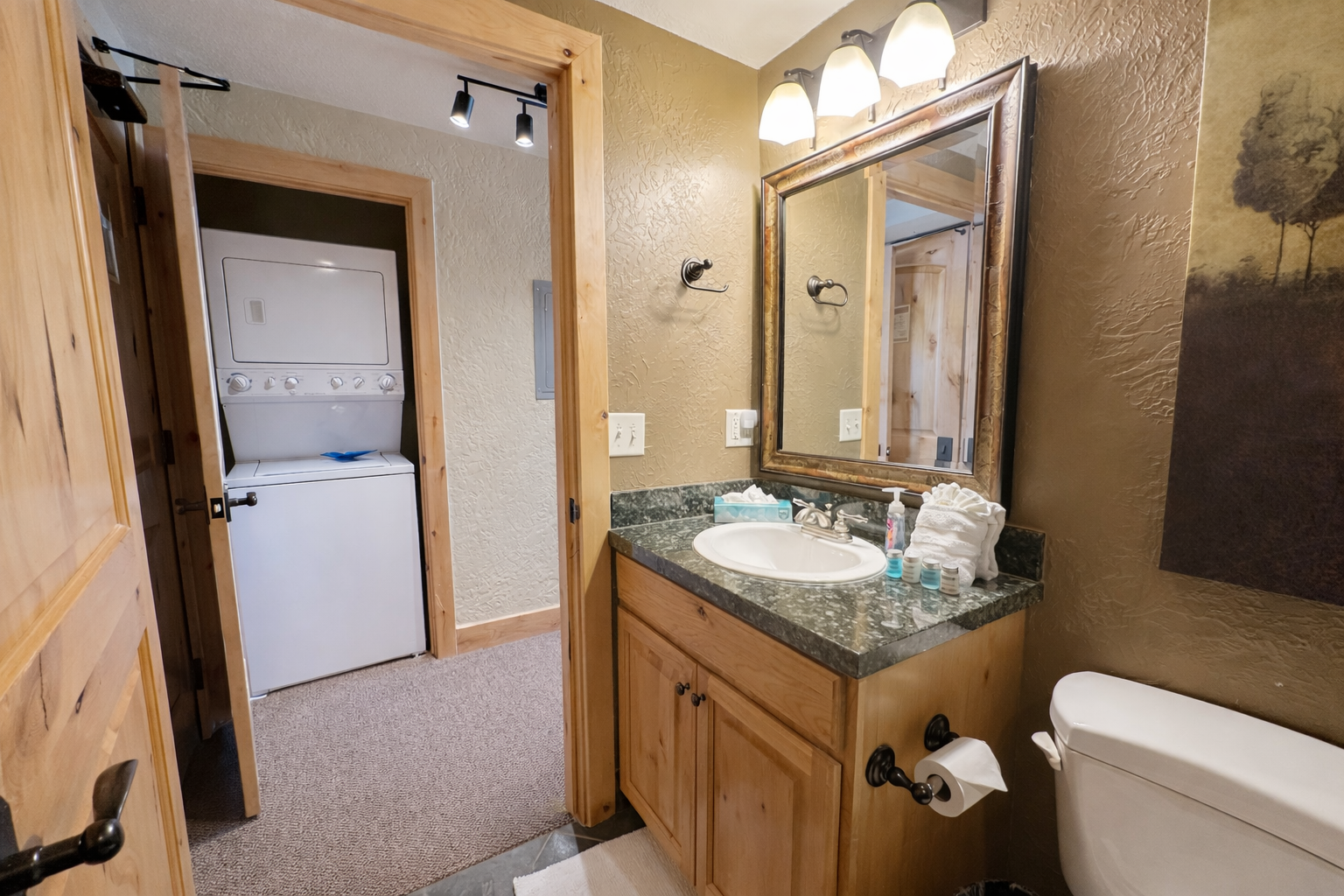 Unwind in your private bathroom featuring granite counters, rustic wood cabinetry, and a relaxing tub-shower combo with elegant tile work.
