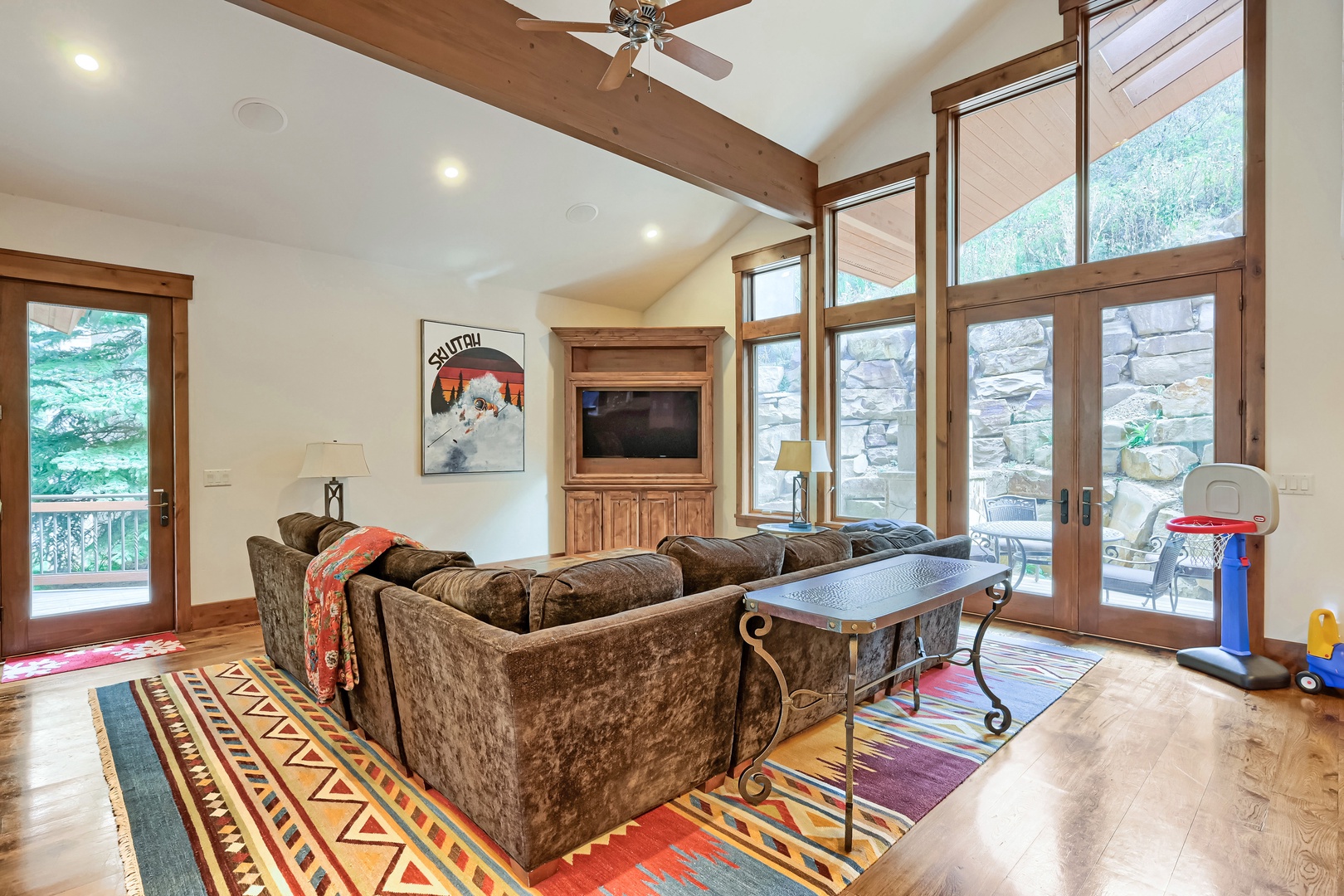 Sink into plush seating under soaring vaulted ceilings, where expansive windows frame your peaceful forest escape and a private balcony awaits your morning coffee.