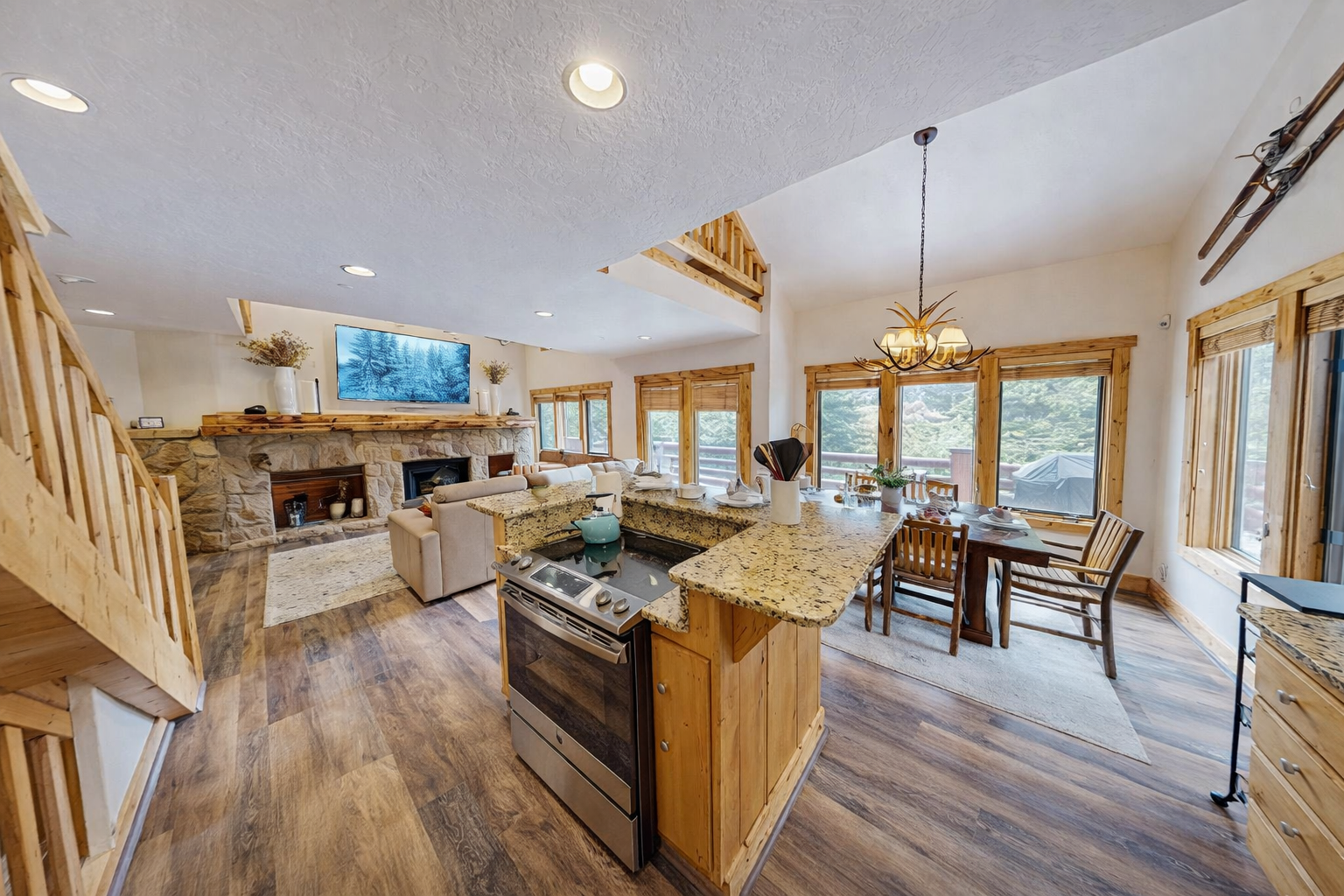 Your open-concept kitchen flows beautifully into the living area, with granite counters, cozy fireplace, and warm wood accents creating the perfect mountain retreat atmosphere.