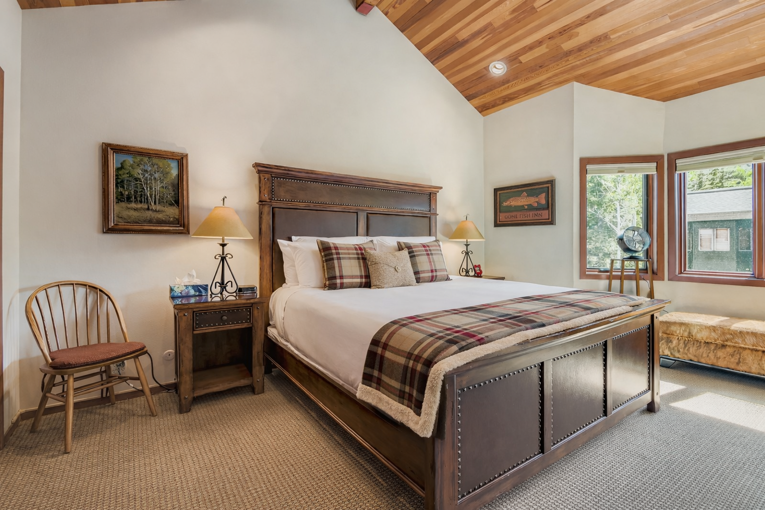 Relax in this rustic-elegant bedroom with warm wood details and cozy plaid accents creating your perfect mountain retreat sanctuary.