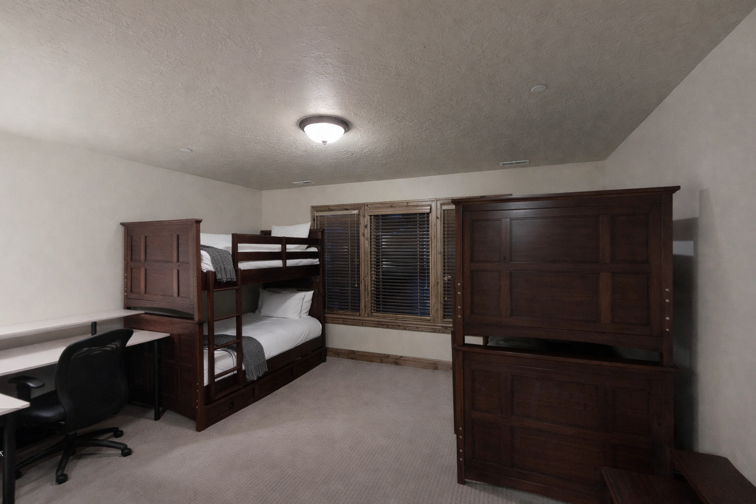 Cozy bunk room with rich wood furniture and built-in entertainment center creates your perfect retreat for restful nights.