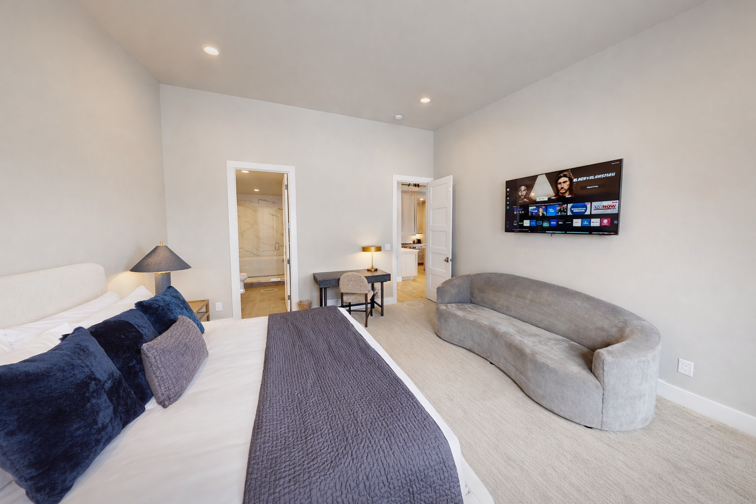 Sink into plush bedding and unwind on the curved sofa while enjoying your favorite shows on the smart TV in this serene retreat.