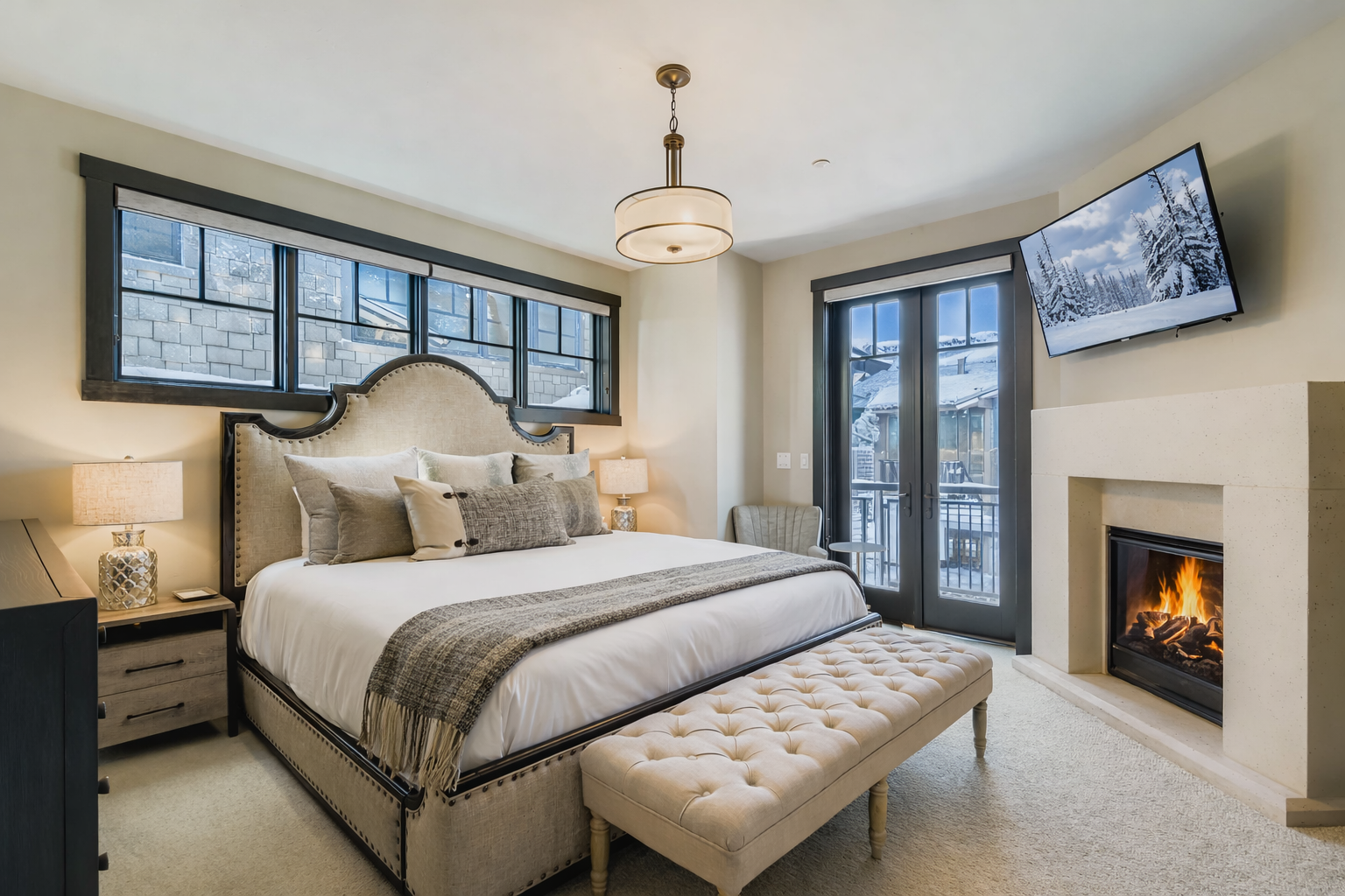 Relax in this bright, sophisticated primary suite featuring a plush king-sized bed, elegant tufted bench, and ample storage. Large windows offer natural light, creating a serene, stylish urban retreat.