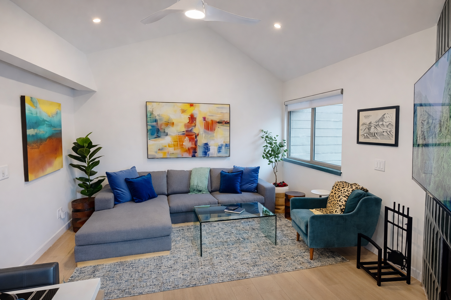 Sink into the plush sectional and unwind in this stylish living room, where vibrant artwork and modern furnishings create your perfect relaxation retreat.