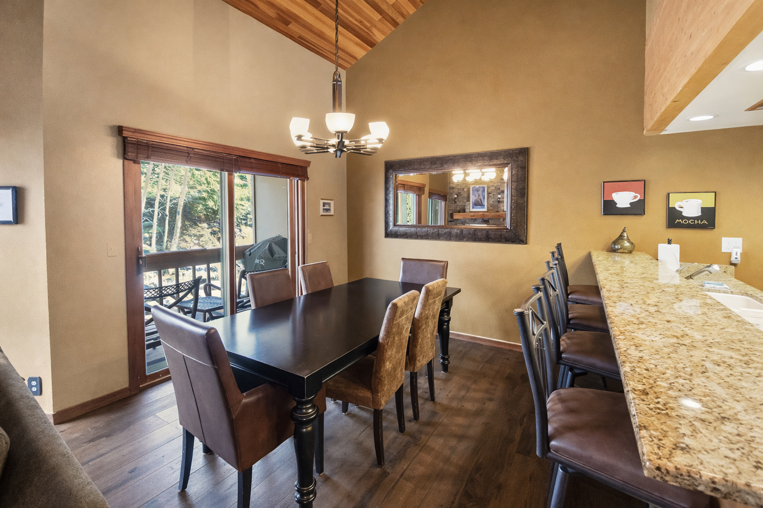 Gather for memorable meals in this spacious, cabin-style dining room. Features a large table, natural light, and peaceful views of the outdoors.