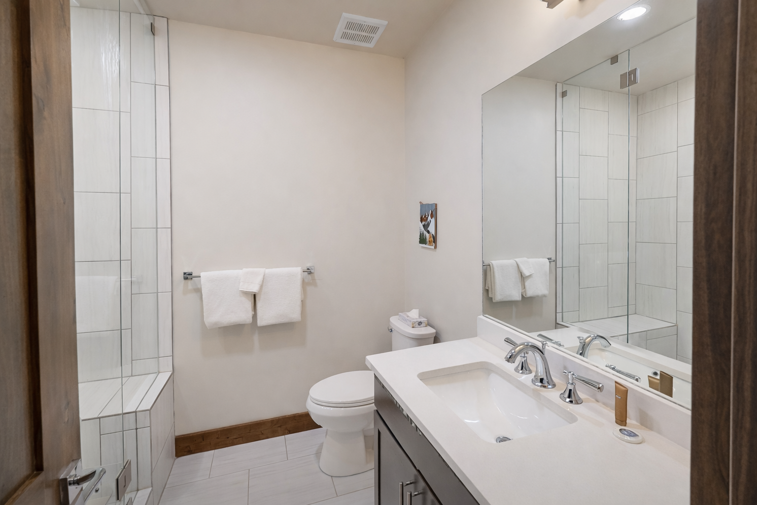 Refresh in this bright ensuite bathroom featuring a sleek glass-enclosed shower and a large vanity with ample counter space. It’s a clean, modern retreat conveniently located just off the bedroom.