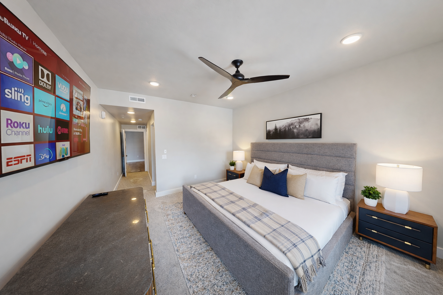 Retreat to this tranquil, modern primary suite featuring a plush king-sized bed with a stylish channeled headboard. Soft, neutral tones and a spacious layout create a serene sanctuary for your ultimate relaxation.